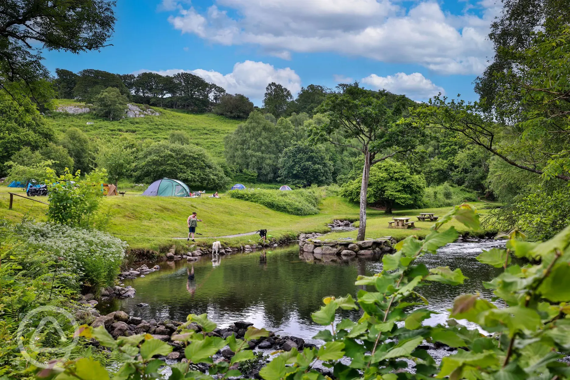 Grass camping pitches by the waterfall