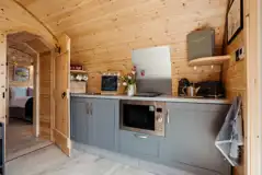 Luxury ensuite glamping pod kitchen with combi microwave, hob and fridge freezer