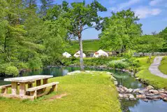 Bell tents by the river with a double bed and two single sofa beds