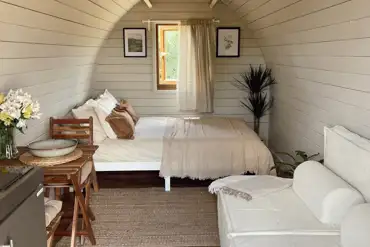 Glamping pod with a double bed and seating at Meadow View Country Park