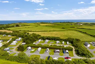 Aerial of hardstanding and grass pitches with sea views