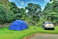 Grass tent pitch with parking along side