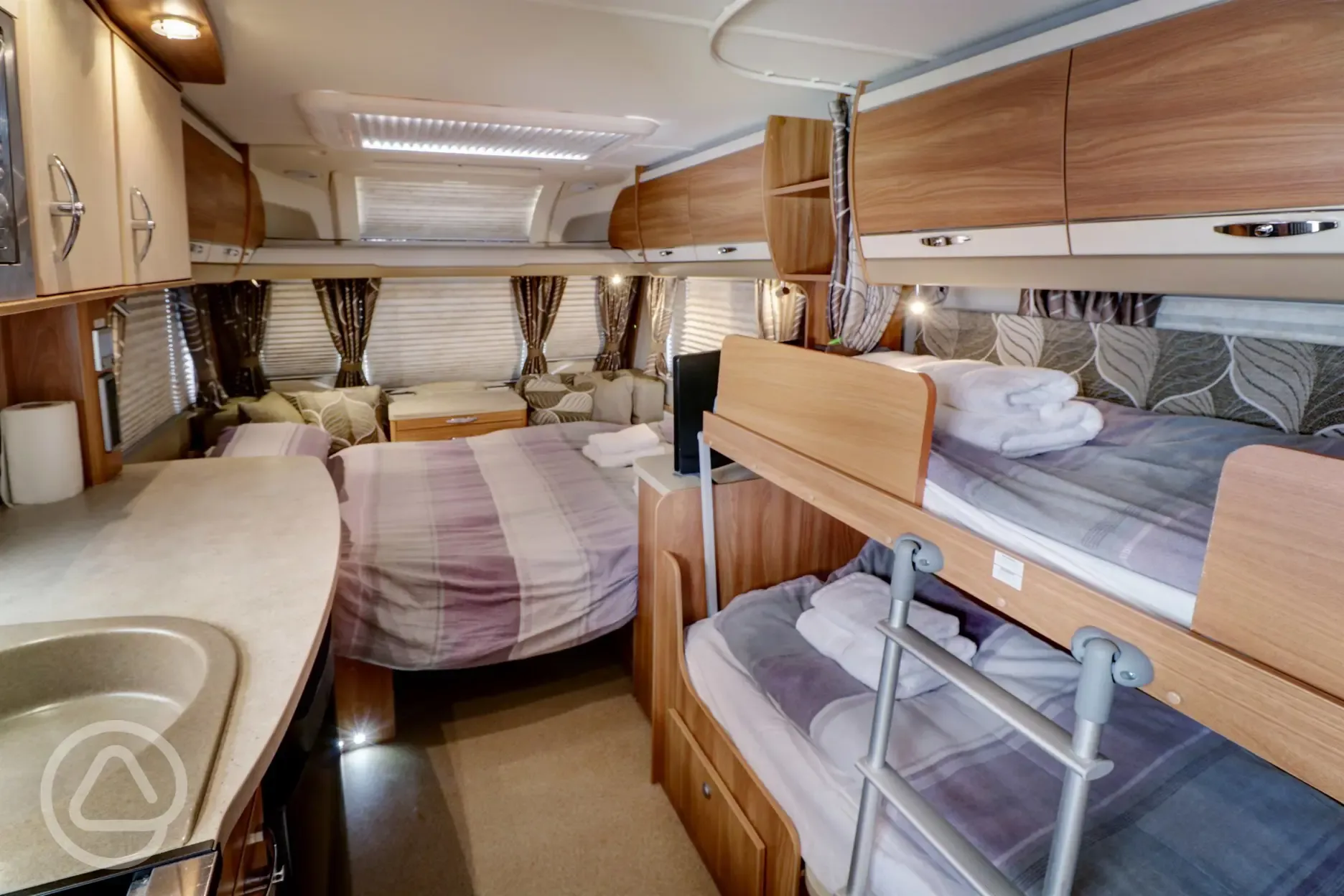 Caravan interior with double bed and bunk beds
