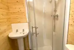 Pine/Ash lodge ensuite bathroom with a shower, toilet, and sink