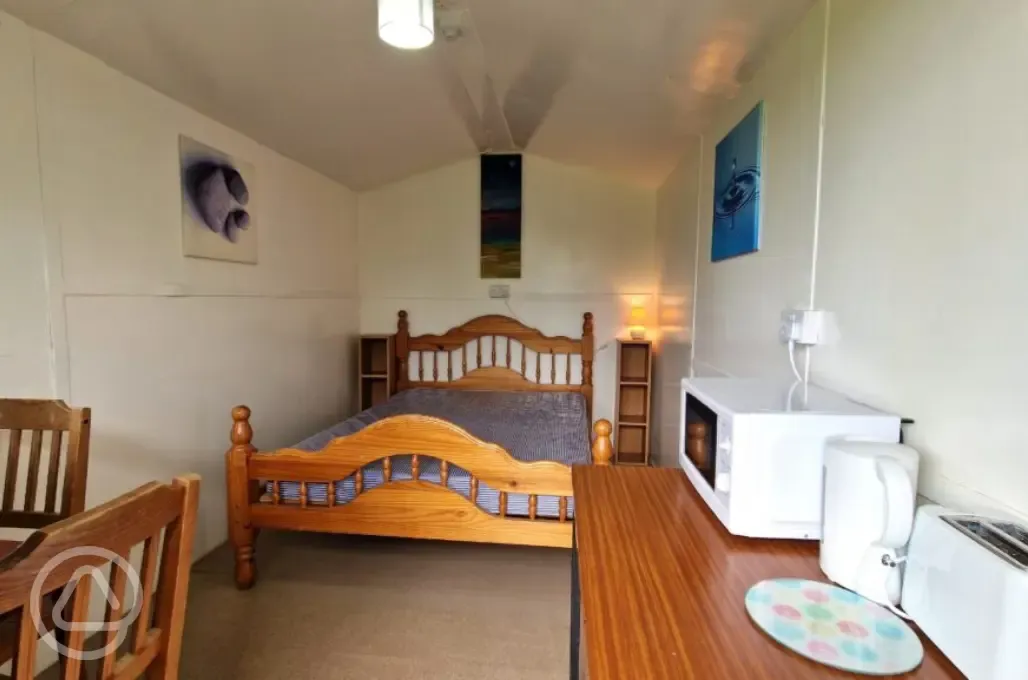 River View huts two person interior with a double bed, microwave, and kettle