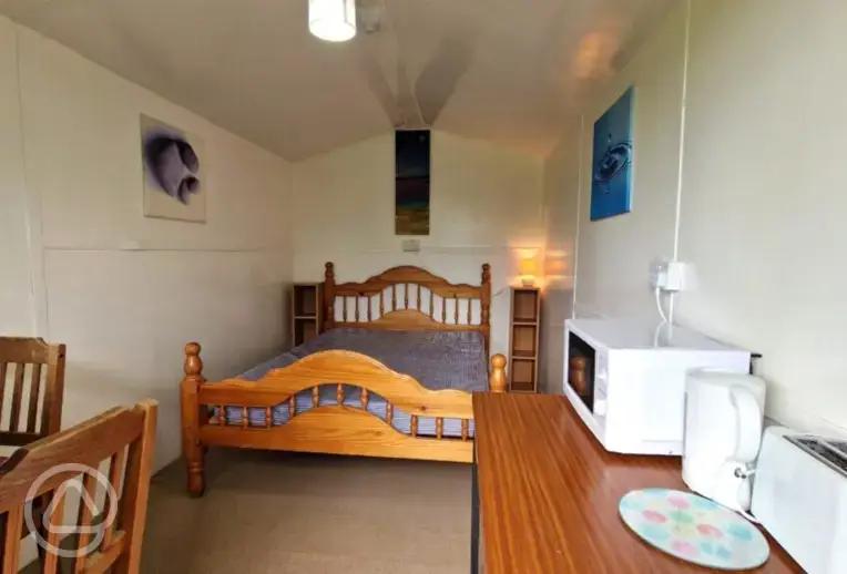 River View huts two person interior with a double bed, microwave, and kettle