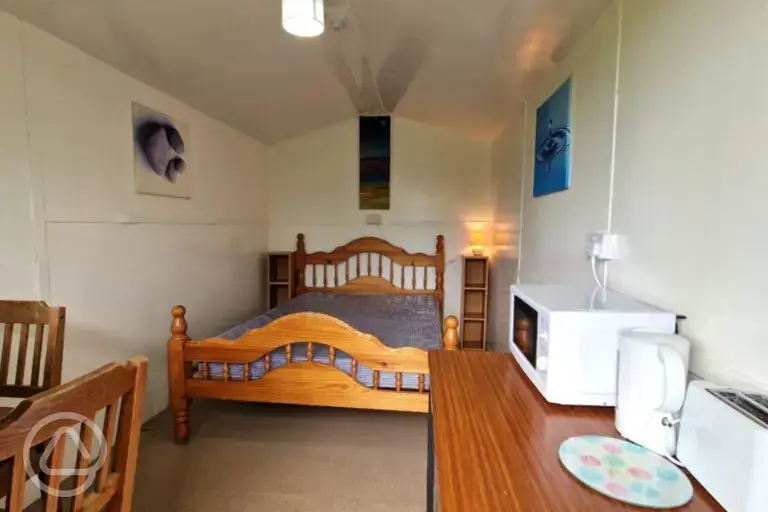 River View huts two person interior with a double bed, microwave, and kettle