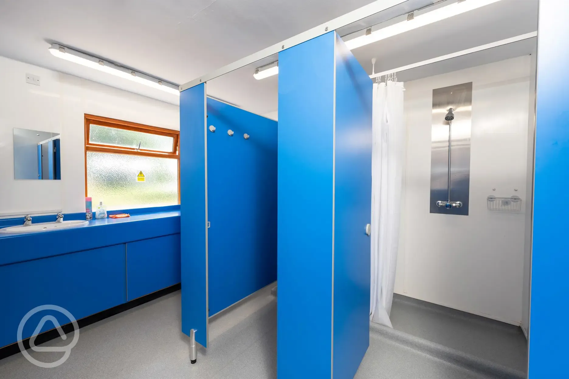 Showers cubicles with curtains, shelf for toiletries, and hooks Showers cubicles with curtains, shelf for toiletries, and hooks