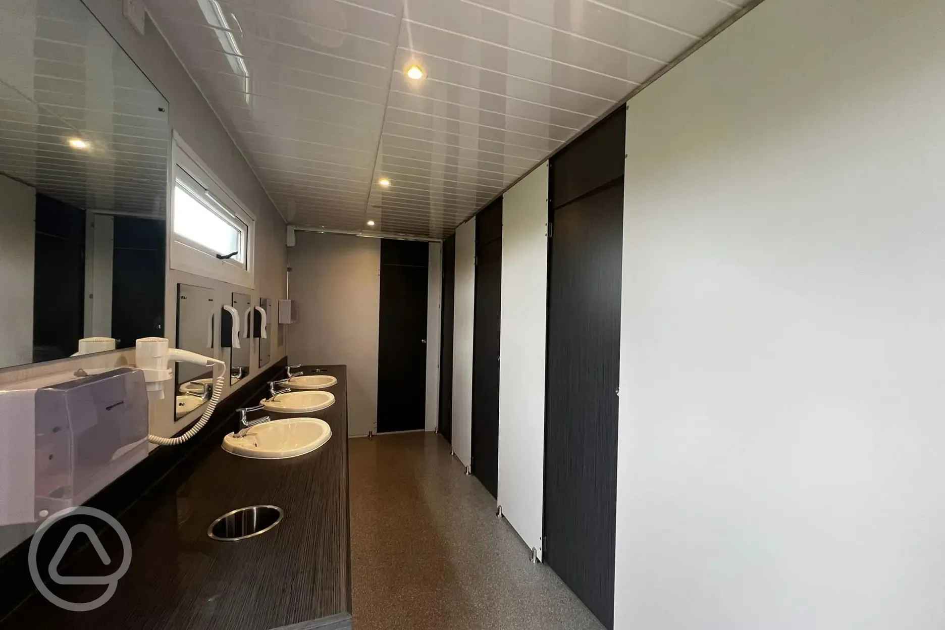 Facilities block interior with cubicles, sinks and mirrors