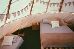 King-sized and single bed inside a tipi at White House on Wye Glamping