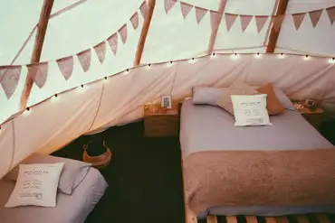 King-sized and single bed inside a tipi at White House on Wye Glamping