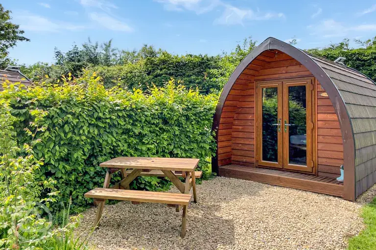 Camping pod exterior with private outdoor dining area