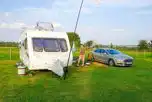 Electric grass caravan pitch with space for a parked car