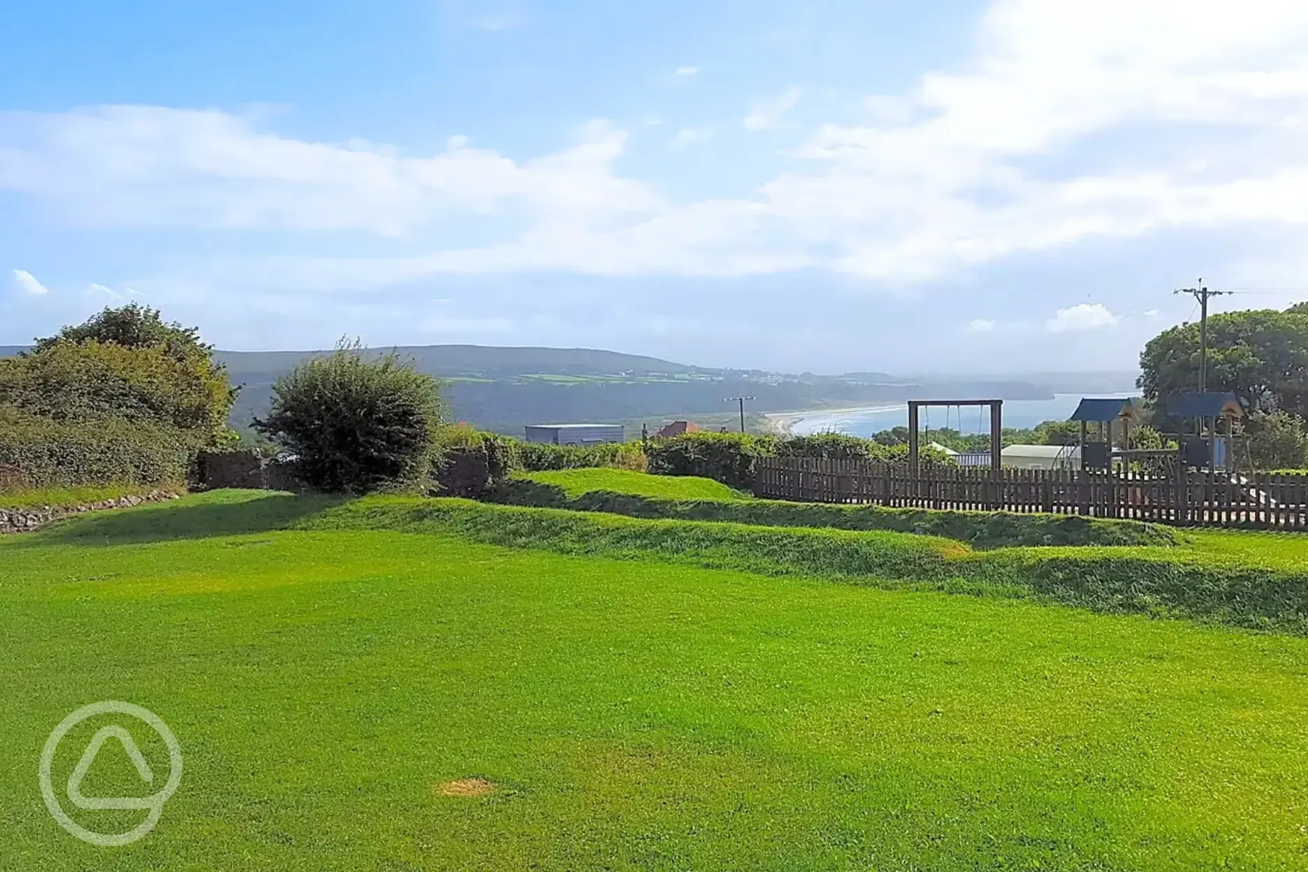 Non electric grass pitches next to the play area overlooking Oxwich Bay