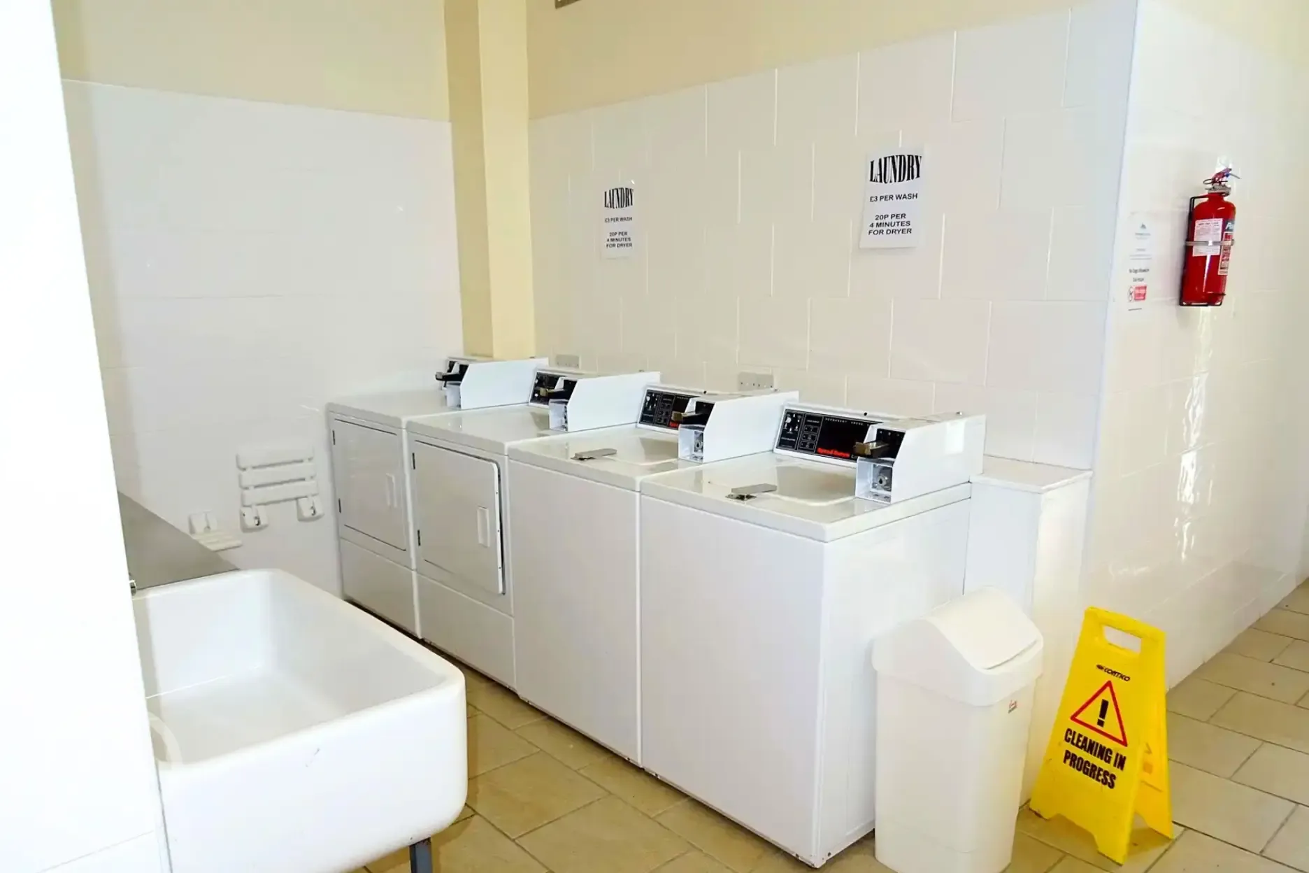 Coin-operated laundry room with washing machines and tumble dryer