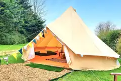 Bell tents with outdoor seating and bunting