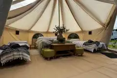 Skyview bell tent interior with a double futon bed and two single futons