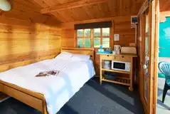 Cosy Cabin interior with double bed, kettle and microwave