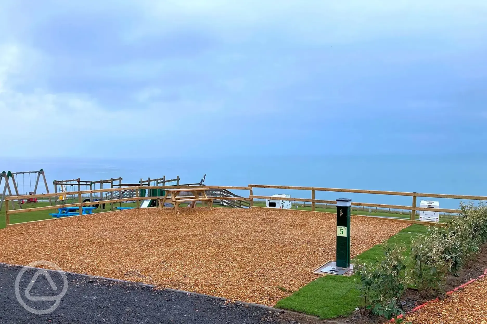 Peregrine fully serviced gravel motorhome pitch with playground in distance