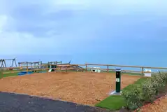 Peregrine fully serviced gravel motorhome pitch with playground in distance