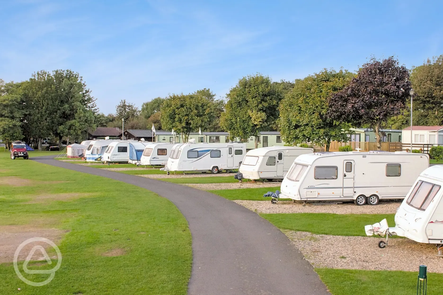 Electric hardstanding touring pitches with grass areas to divide pitches