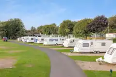 Electric hardstanding touring pitches with grass areas to divide pitches