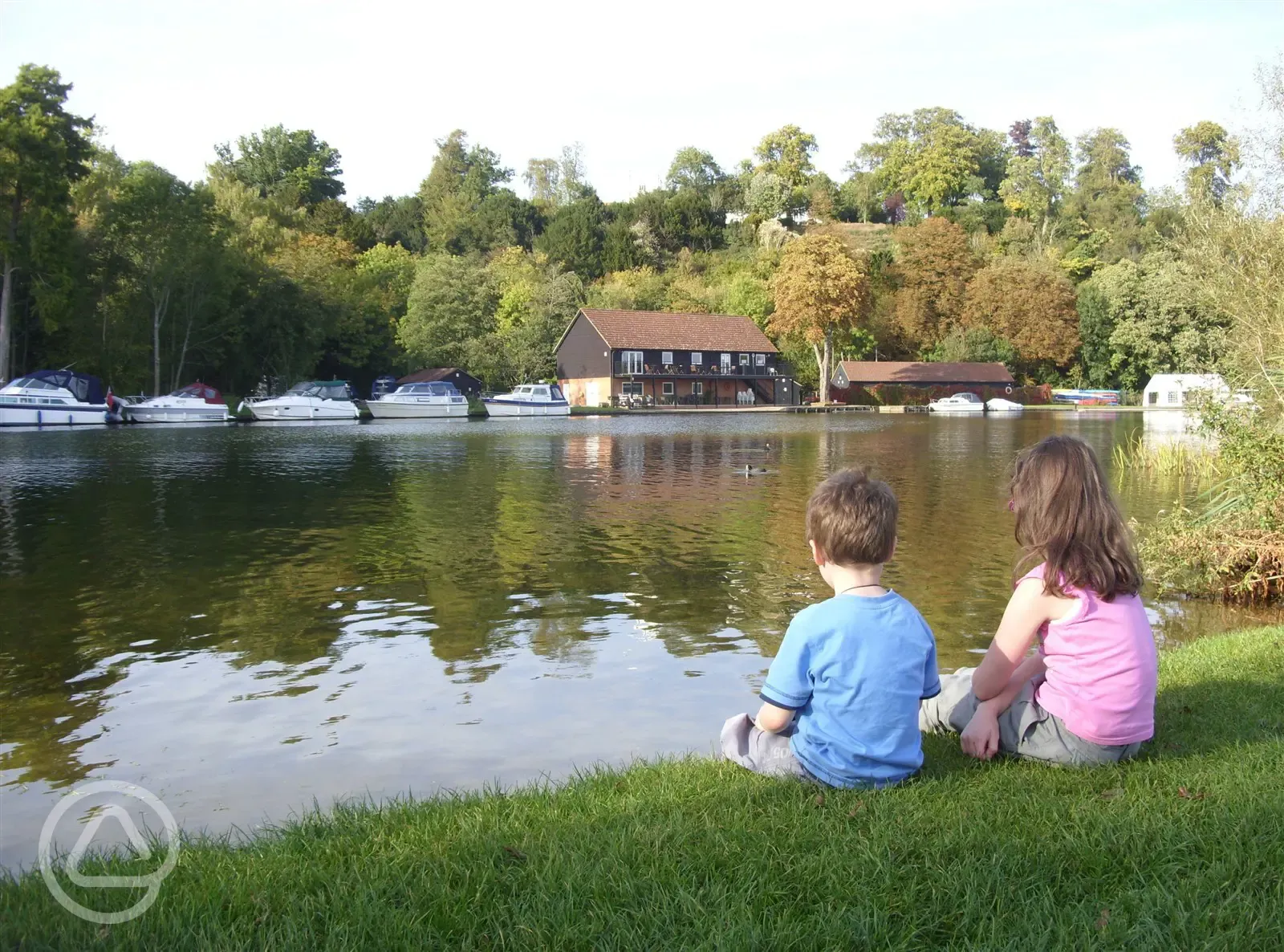 Children sat beside Hurley Riverside Park's river bank