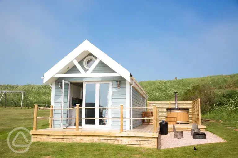 Deluxe ensuite beach hut with a wood-fired hot tub, fire pit and seating