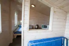 Standard beach hut interior with twin beds and a small kitchen area Standard beach hut interior with twin beds and a small kitchen area