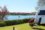 Electric grass pitches overlooking lake at Fishery Creek Touring Park