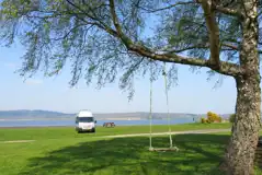 Non electric grass pitches by the waterfront with picnic benches around site Non electric grass pitches by the waterfront with picnic benches around site