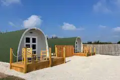 Glamping pods with a small wooden deck and seating area