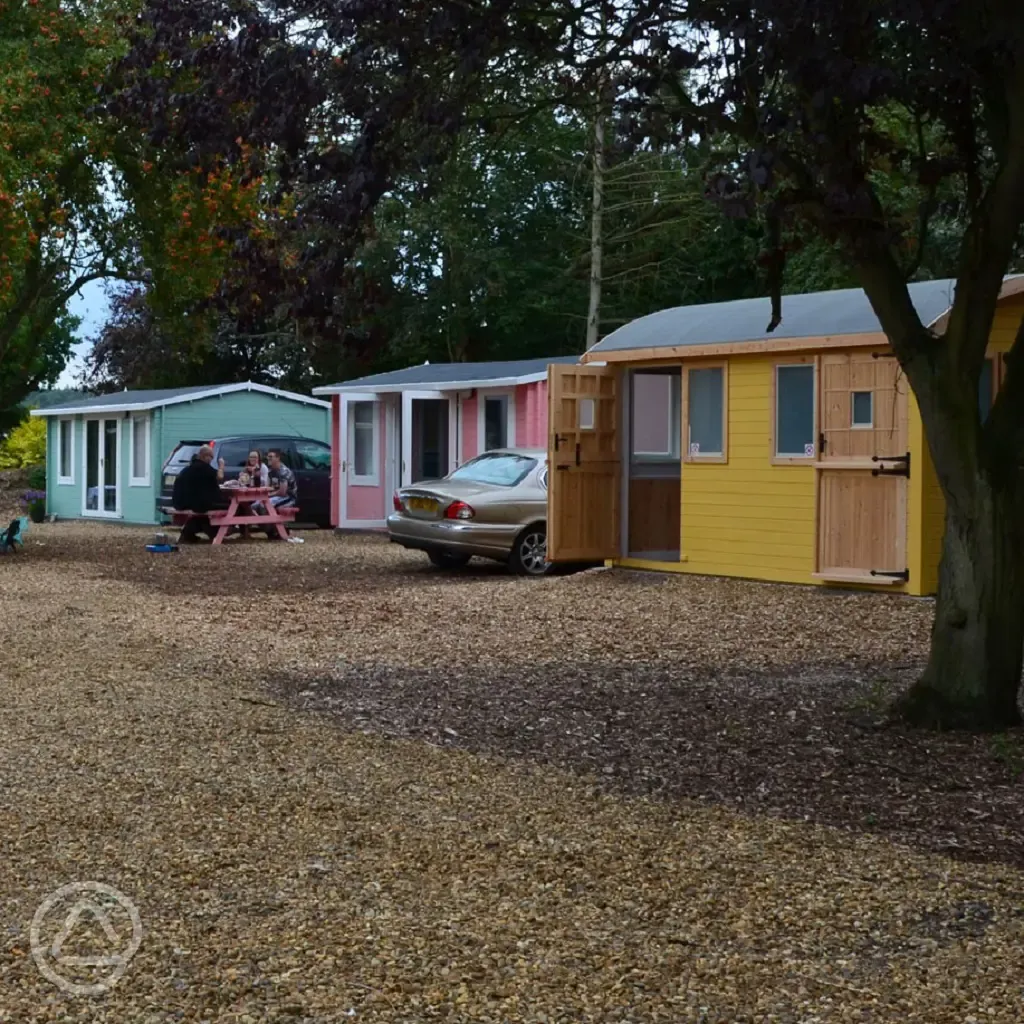 Beach hut cabins with parking spaces and picnic benches