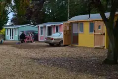 Beach hut cabins with parking spaces and picnic benches