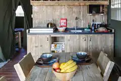 Safari tent kitchen with crockery, cutlery, and utensils