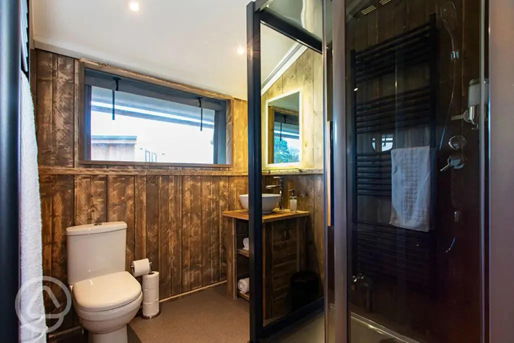 Safari Tent Plus bathroom with shower, toilet, sink and mirror Safari Tent Plus bathroom with shower, toilet, sink and mirror