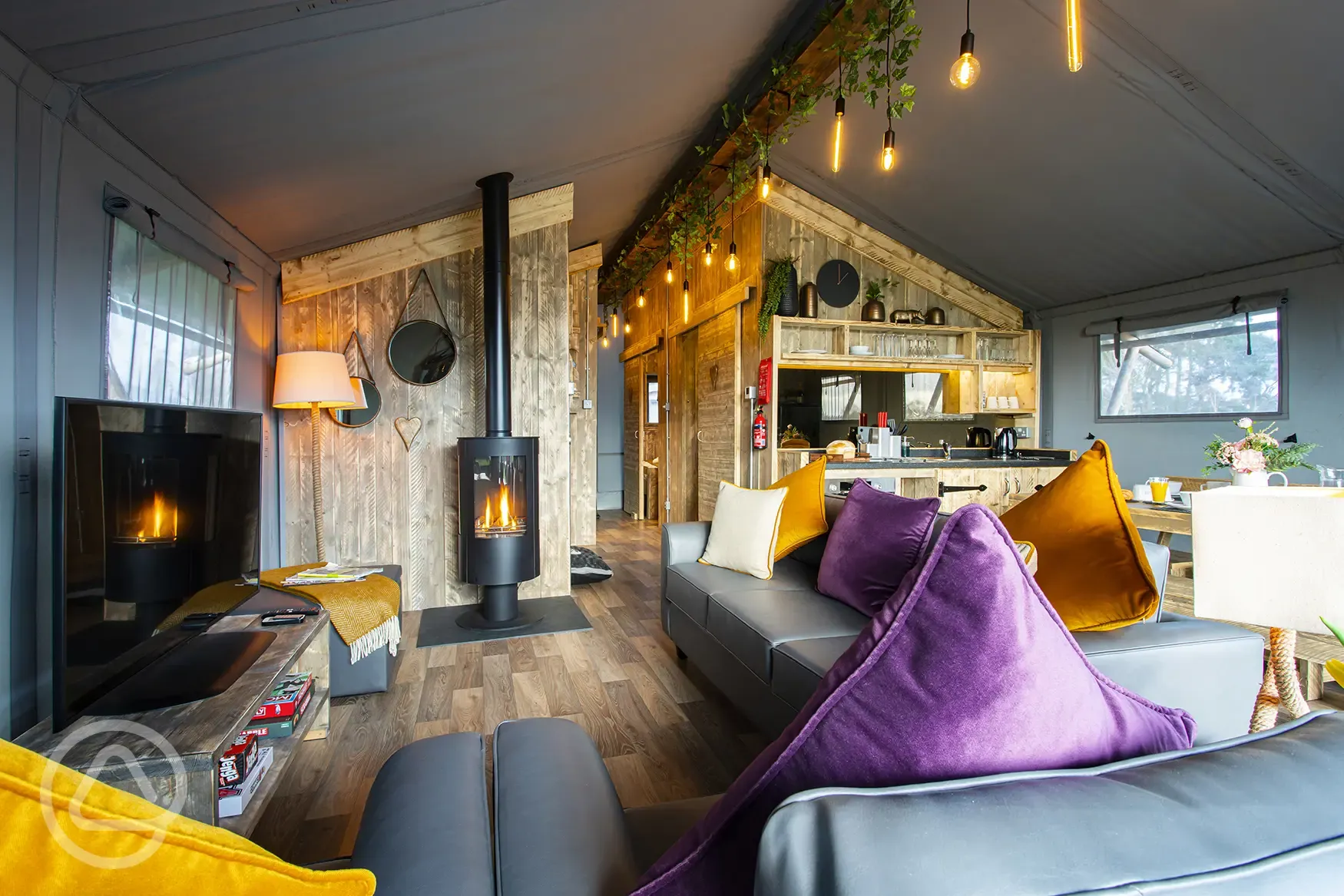 Safari Tent Plus interior with log burner and sofa Safari Tent Plus interior with log burner and sofa