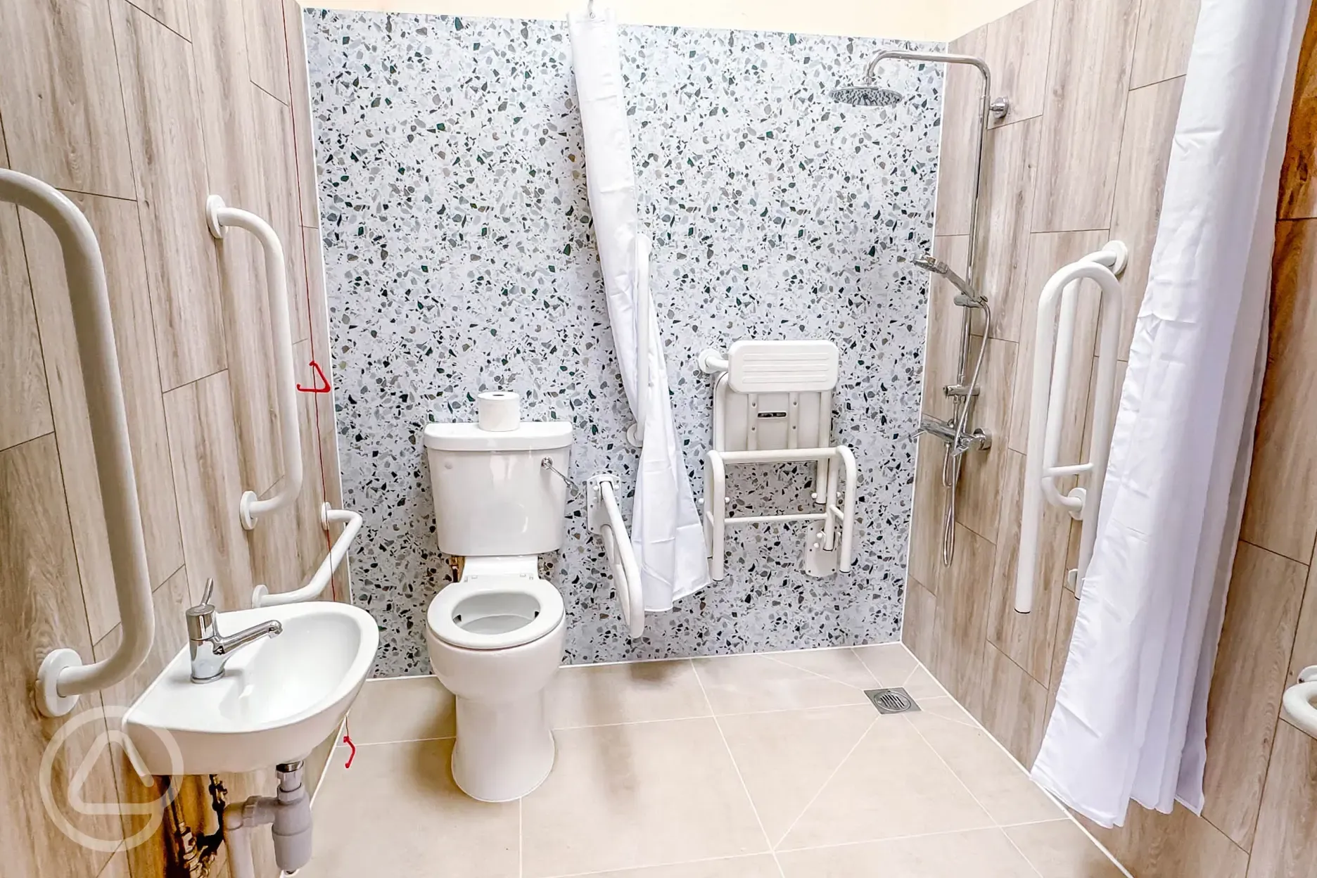 Heated accessible bathroom with grab rails and a shower chair
