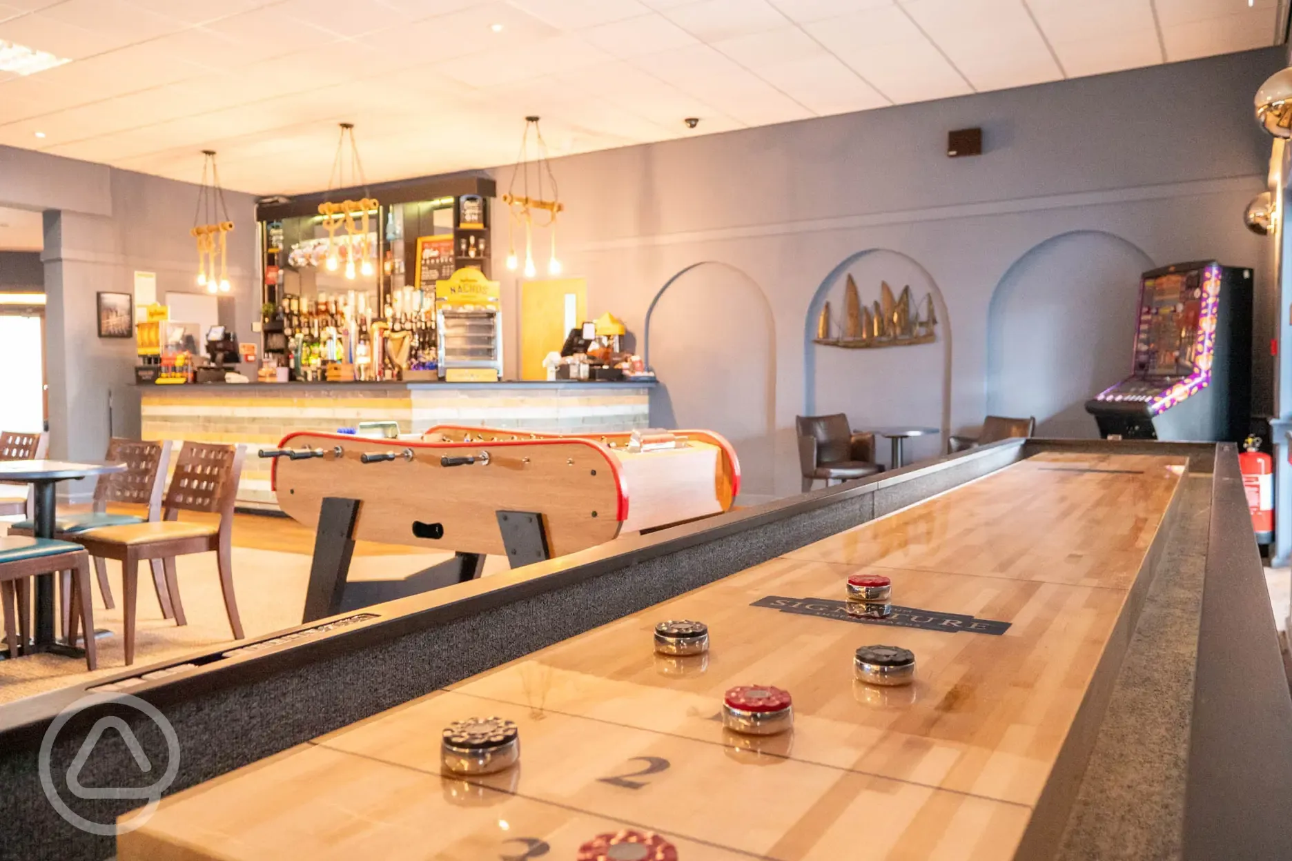 Saltwater pub interior with a bar, seating, and games
