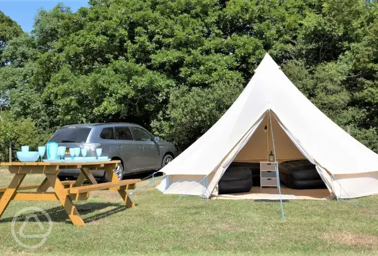Bell tents exterior with parking space and picnic bench