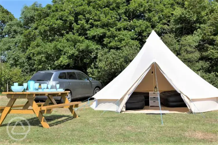 Bell tents exterior with parking space and picnic bench