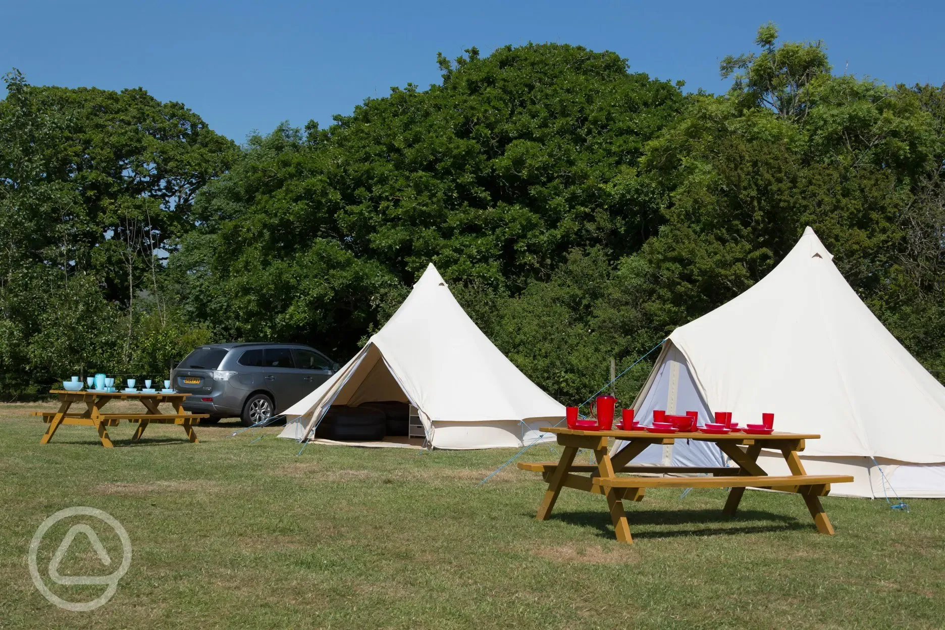 Bell tents exterior with parking space and picnic bench