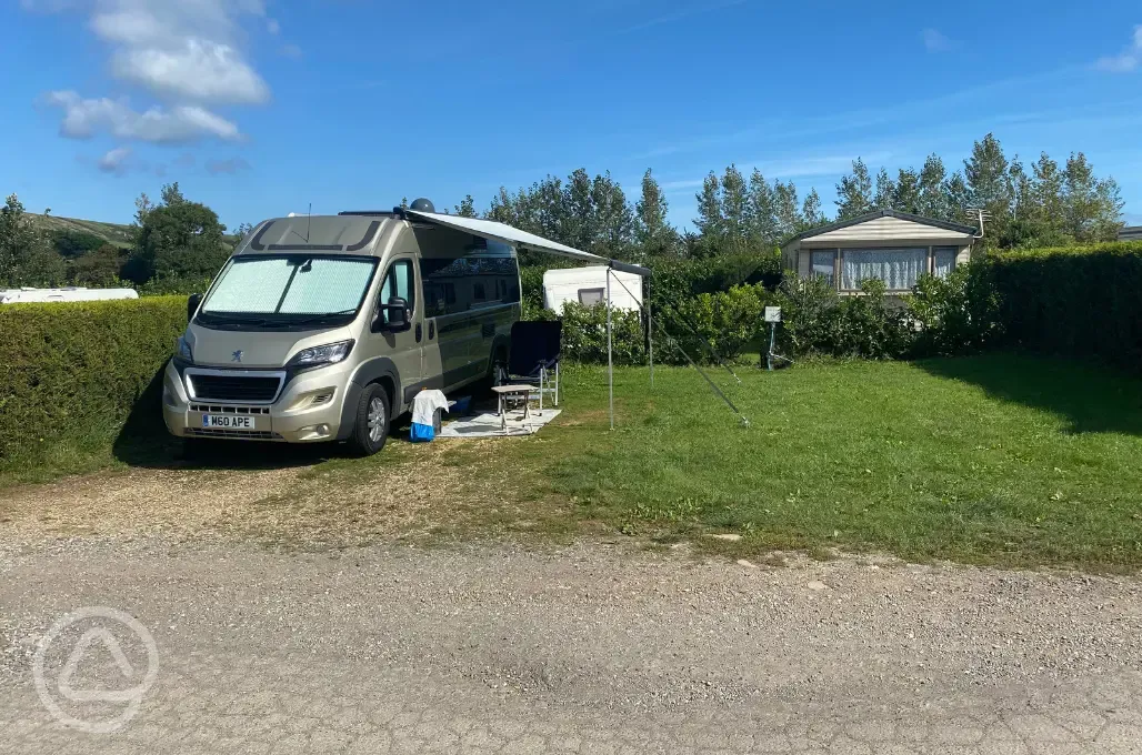 Large fully serviced hardstanding pitches with awning space and individual lawns