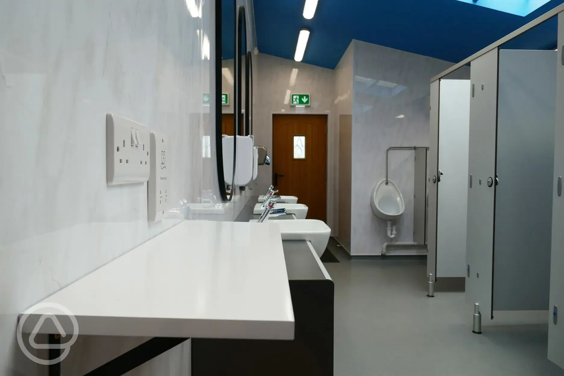 Men's bathoom with cublicles, sinks and mirrors