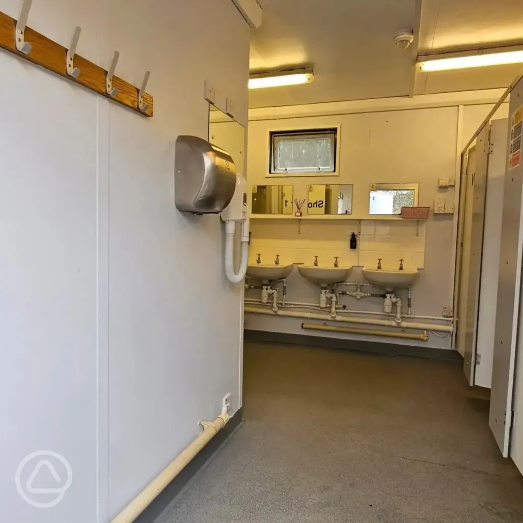 Facilities interior with cublicles, sinks, mirrors, hairdryer and hand dryers