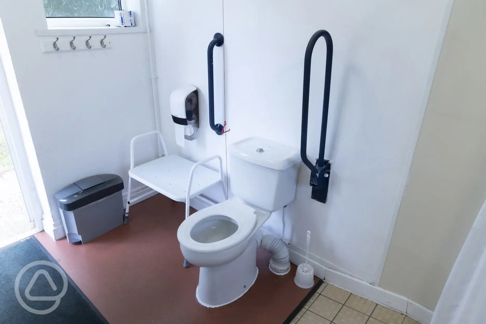 Accessible toilet with grab rails and seating 