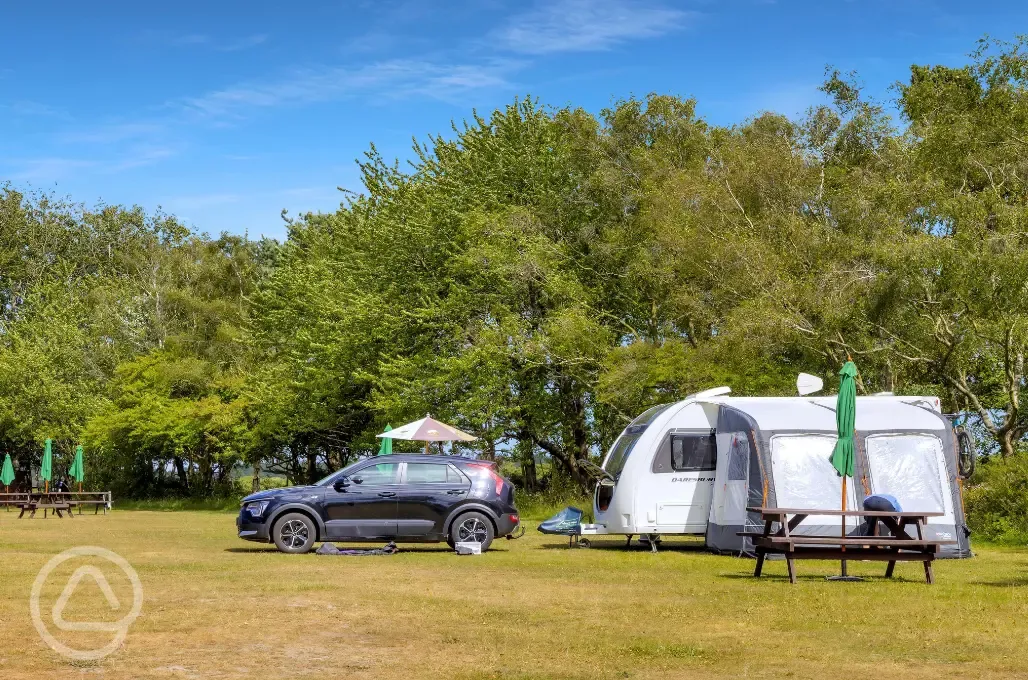 Non electric grass pitch with a picnic table and an awning