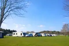 Tourers on electric grass pitches with space for a parked car