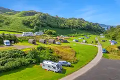 Aerial of Oban Holiday Park, surrounded by hills and with views towards the sea