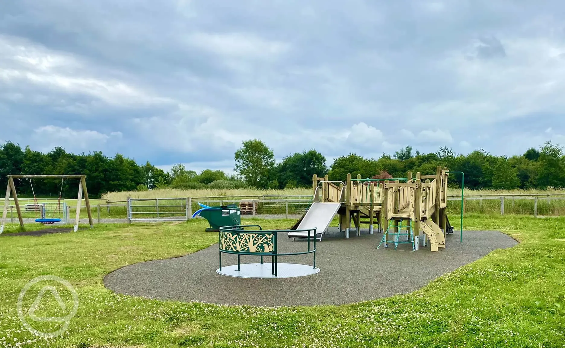 Children's playground in the orange area with swings, slides and roundabout